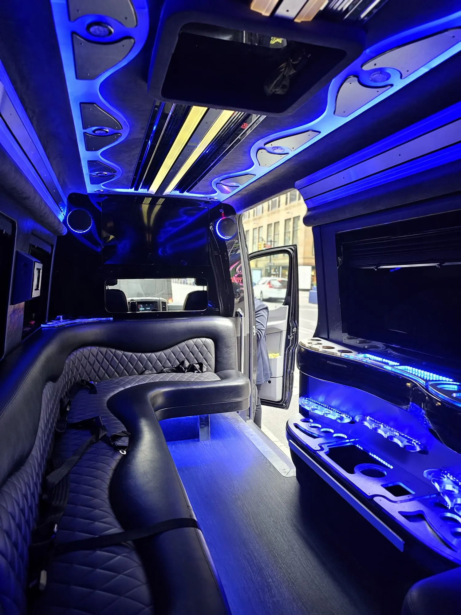 Limo Sprinter interior with perimeter lounge seating and ambient lighting
